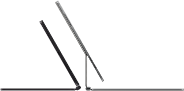 Dva iPady Pro připnuté k Magic Keyboardu, pohled z boku, tenký profil, vesmírně černá barva, reproduktory a USB‑C port, jeden napůl otevřený, druhý ve stříbrné barvě otevřený a nakloněný dozadu, takže je vidět plovoucí konzolová konstrukce klávesnice, reproduktory a mikrofon